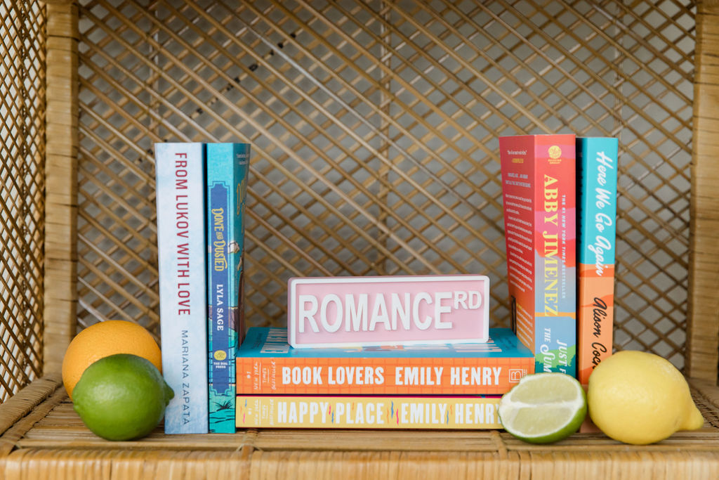 Books stacked on a bookshelf with fruit