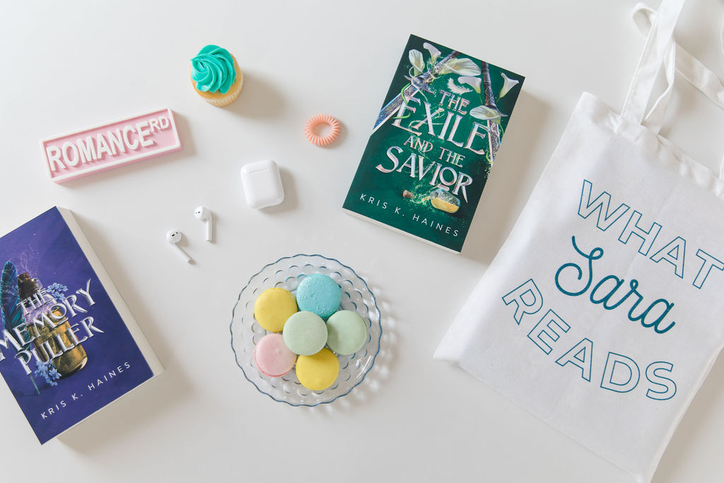 Fantasy books for women sitting on a counter with desserts and a tote bag