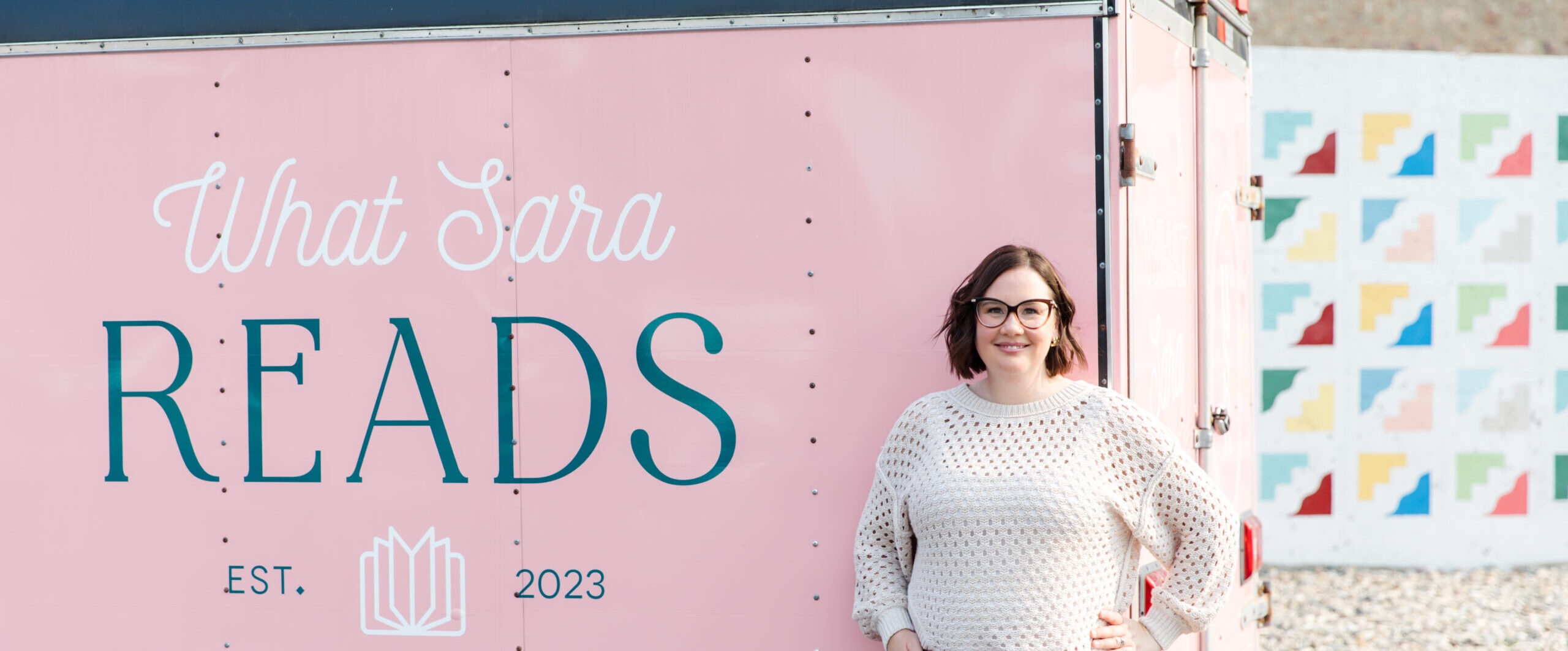 Sara standing in front of her mobile bookstore trailer